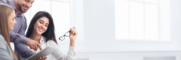 Happy business colleagues discussing new project in office Happy business colleagues discussing new project together in office, copy space group of people wearing eyeglasses stock pictures, royalty-free photos & images