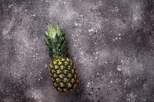 Pineapple on gray concrete background. Top view