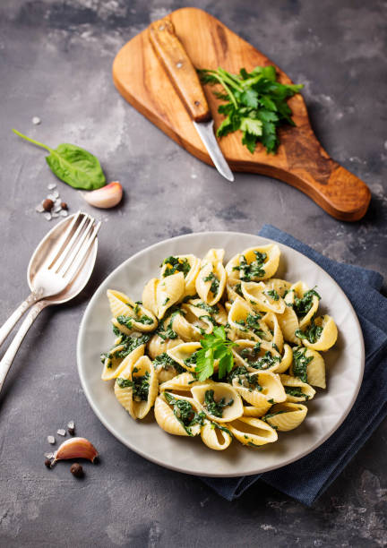 istock Conchiglioni pasta with spinach in creamy sauce 1086834868