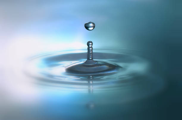 goccia d'acqua limpida e calma sull'acqua blu opalescente - opalescent foto e immagini stock