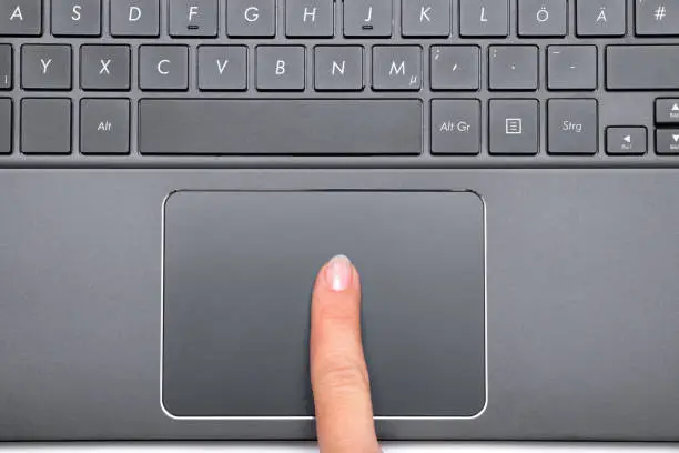 Indexfinger of a woman on Notebook Touchpad