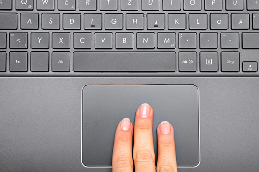 Tres dedos de una mujer en Touchpad Notebook photo