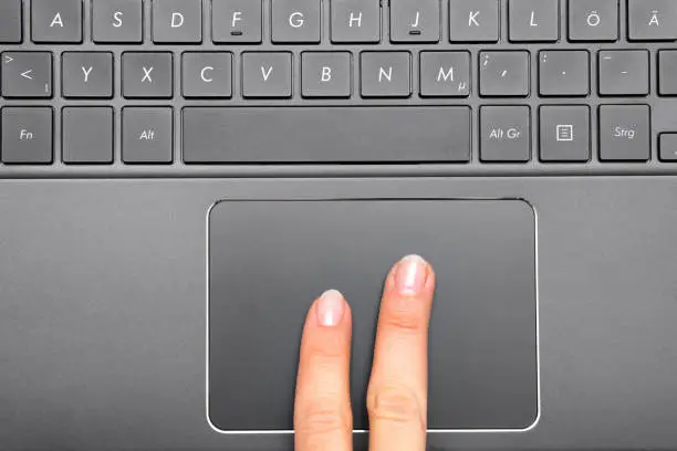 Indexfinger of a woman on Notebook Touchpad