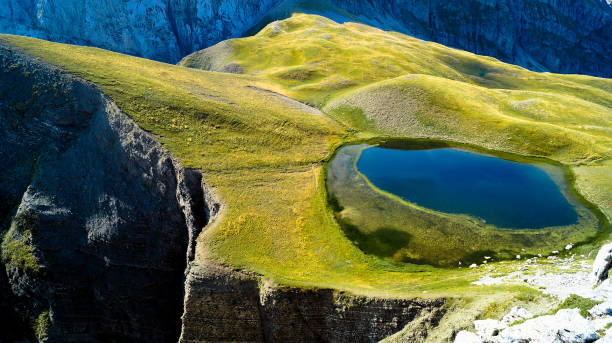 Drakolimni (dragon lake) The pristine alpine lake of Drakolimni high in the mountains at the Zagori area, Epirus. zagori stock pictures, royalty-free photos & images