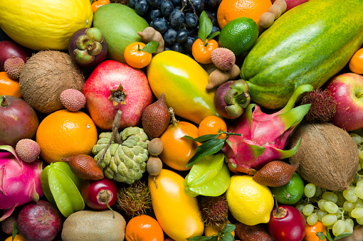 Top view of various multicolored fruits and vegetables disposed at the borders of the image on a frame shape leaving a useful copy space at the center on white background