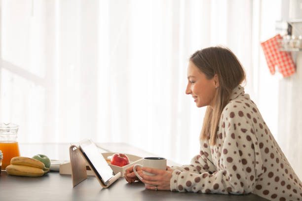 istock Woman drinking tea and video chatting at home 1086845660