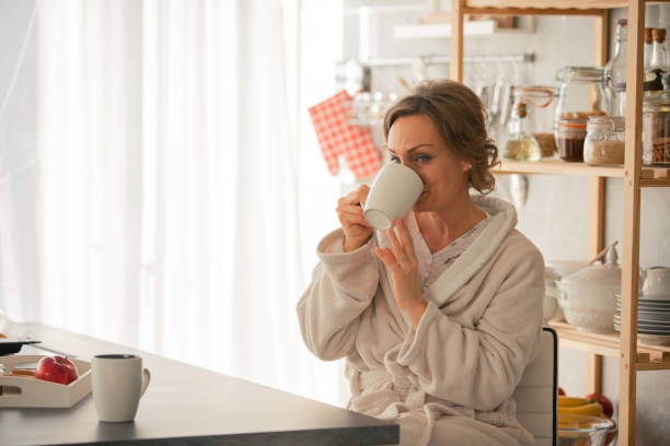 istock Mature woman drinking morning tea in the kitchen 1086845714