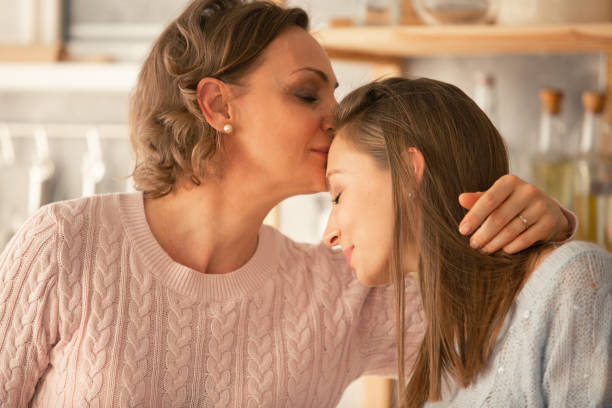 istock Mother kissing her daughter on forehead 1086845808