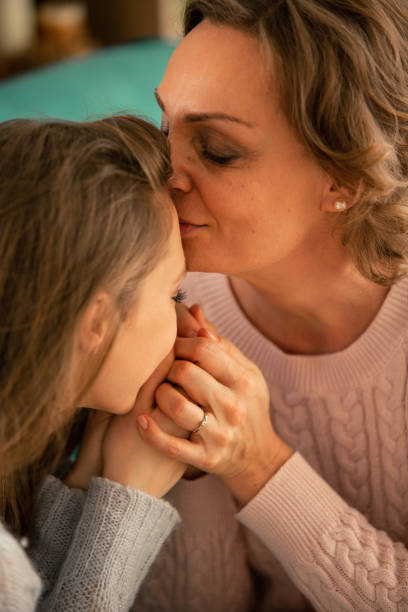 istock Mother kissing her daughter on forehead 1086845858