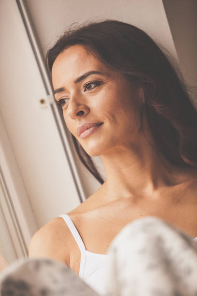 istock Pensive woman looking through the window 1086847912