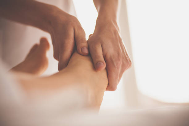 마사지 치료사 여자의 발을 마사지 - foot massage 뉴스 사진 이미지