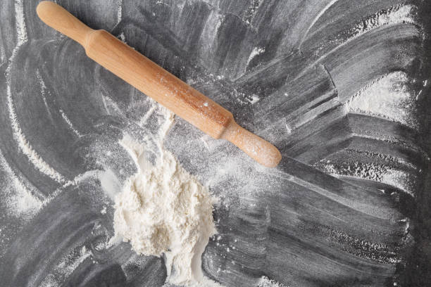 istock Rolling pin and flour on black table. Copy space. Top view 1086851828