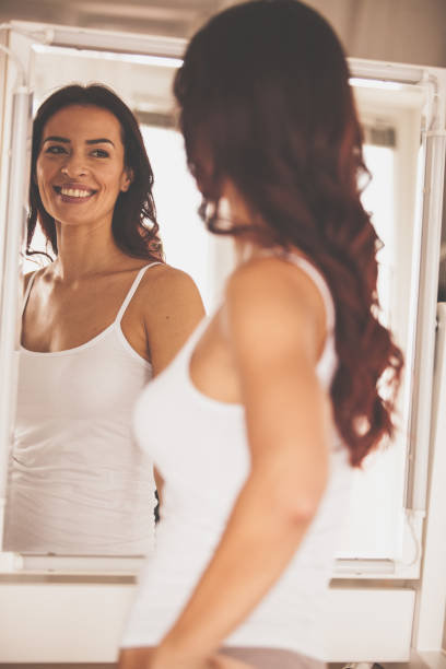 istock Satisfied woman looking at her reflection in the mirror 1086851928