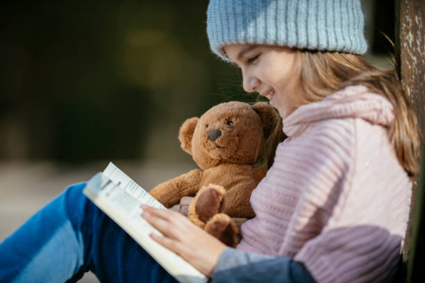 Smiling girl with teddy-bear. Shadow DOF. Developed from RAW; retouched with special care and attention; Small amount of grain added for best final impression. 16 bit Adobe RGB color profile.