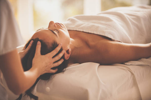 mujer que recibe una cabeza de revitalizante masaje en spa - spa treatment health spa massage therapist women fotografías e imágenes de stock