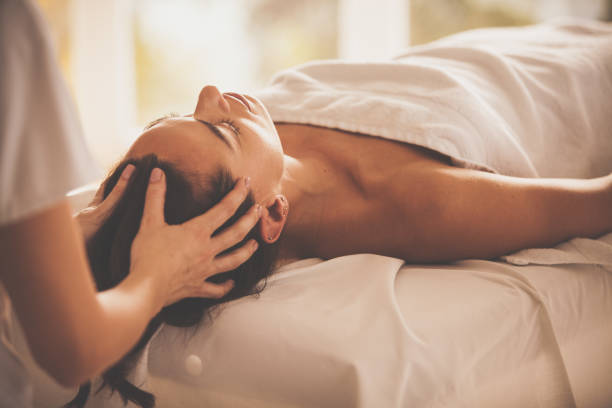 женщина, получаюющая оживляющий массаж головы в спа-салоне - spa treatment head massage health spa healthy lifestyle стоковые фото и изображения