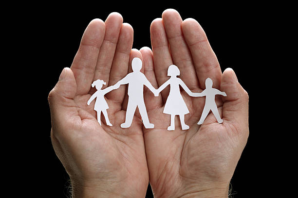 istock Paper cutout chain family protected by cupped hands 108685353
