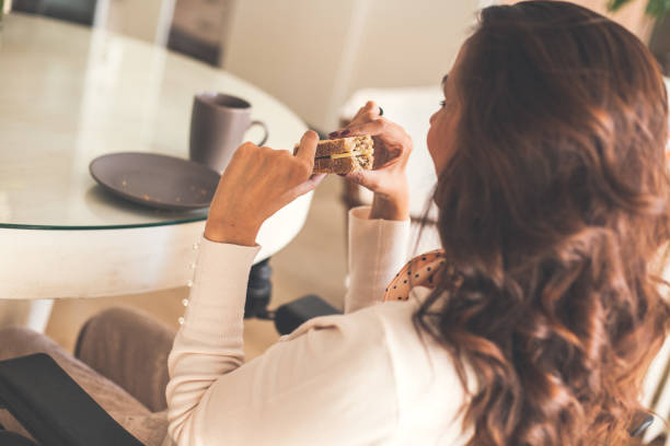 istock Woman eating sandwich for breakfast the dining table 1086855538