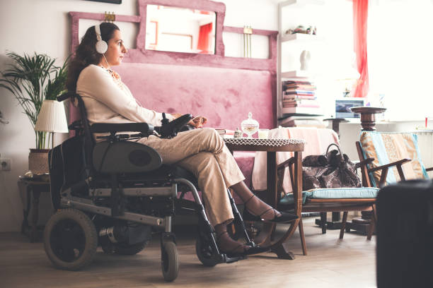 woman with disability relaxing at home - motorized wheelchair audio imagens e fotografias de stock