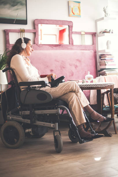 woman with disability relaxing at home - motorized wheelchair audio imagens e fotografias de stock