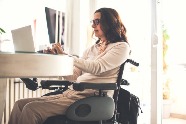 istock Businesswoman with physical disability using laptop at home 1086857238