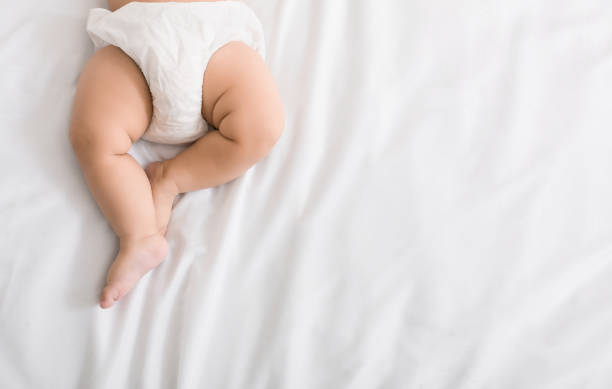 las piernas del bebé y la parte inferior en el pañal en la cama - clean feet fotografías e imágenes de stock