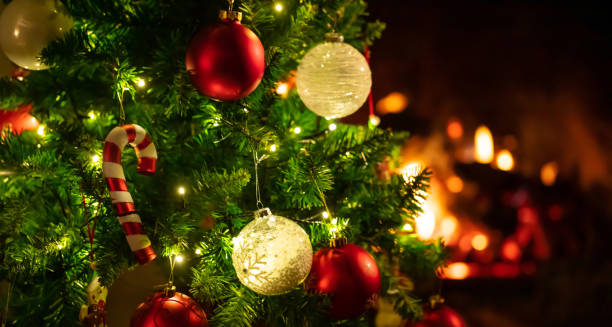 istock Christmas tree close up on blurred burning fireplace background 1086861752