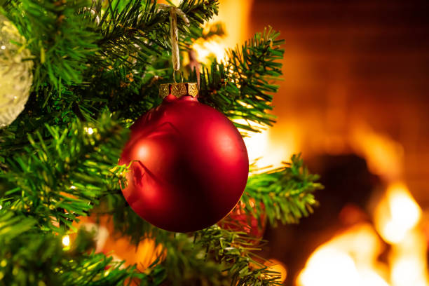 istock Christmas tree close up on blurred burning fireplace background 1086861780
