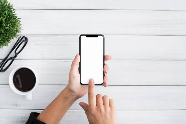 istock Hand using smartphone on white wooden background 1086864082