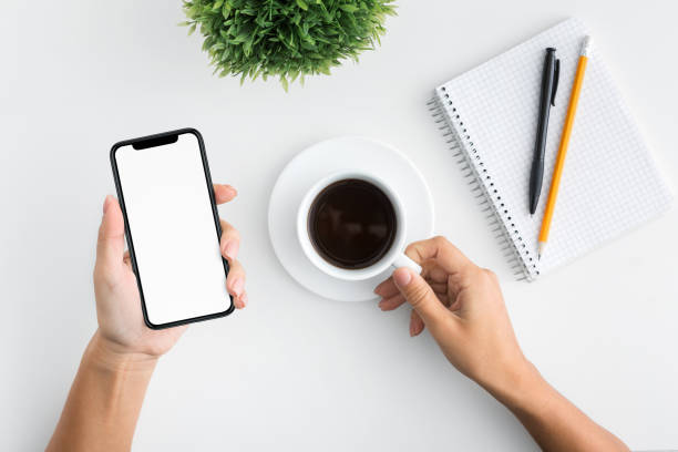 istock Woman holding mobile phone and coffee cup 1086864086