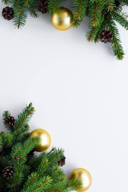 istock Christmas set up with copy space on white background. Nature decorations like conifer tree branches, cones and ornaments: gold baubles. 1086869962
