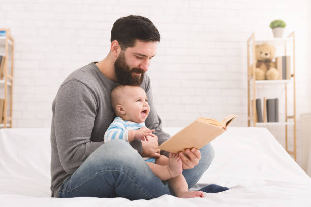 istock Father reading book to little baby son 1086875298