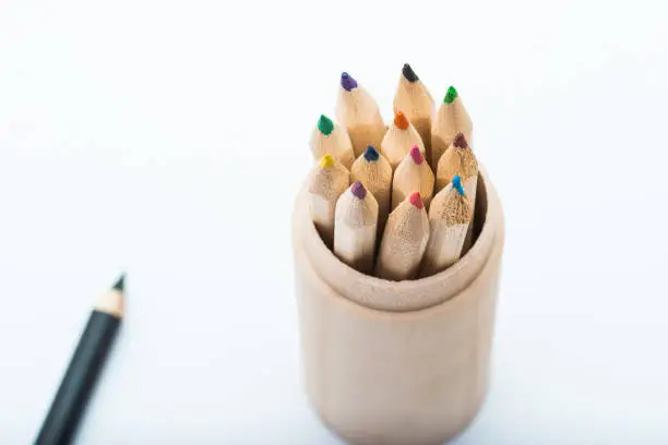 set of colored pencils packed in a wooden cup
