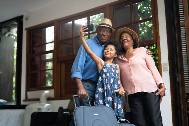 grootouders en kleindochter selfies te nemen na zijn aankomst in een hotel - baggage fotos stockfoto's en -beelden