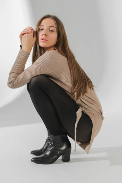 istock woman on haunches in white studio 1086891576