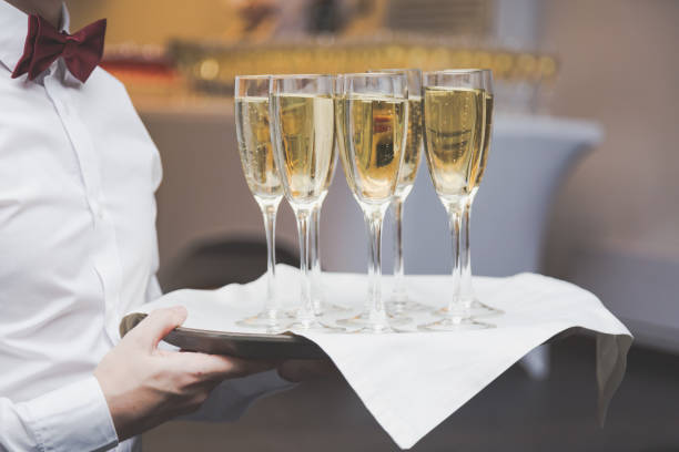 официант, послужя шампанским на подносе в ресторане. - waiter butler champagne tray стоковые фото и изображения