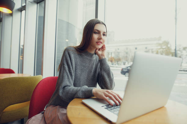 istock Down view. Young business woman sitting at table and taking notes in notebook. Woman working at cafe. Blogger. - Image 1086899510