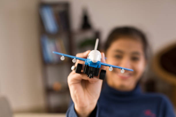 Portrait of girl playing with toy airplane at home