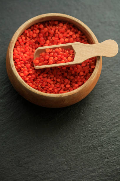 red lentils in a wooden spoon - lentil full frame macro close up imagens e fotografias de stock