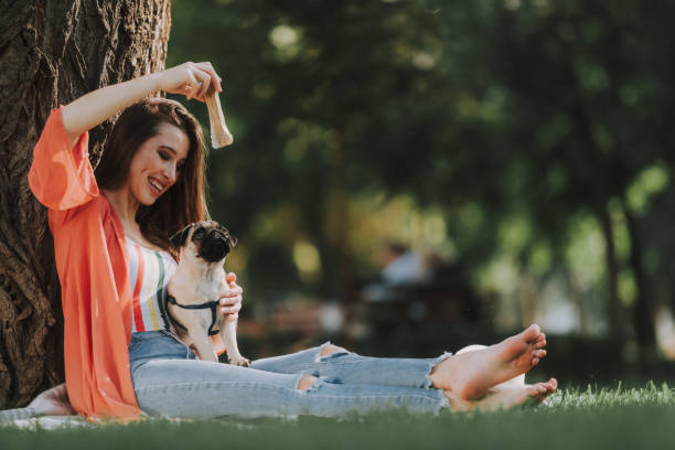 istock Smiling woman is playing with her dog 1086915422