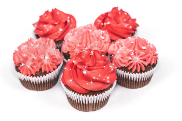 istock Several cupcakes with red and pink icing on isolated white background. 1086918354