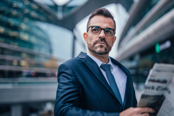 istock Businessman in suit reading newspaper 1086919220