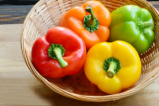 variety of colorful Bell pepper or sweet pepper.
a lot of Capcicum in basket on wooden background.