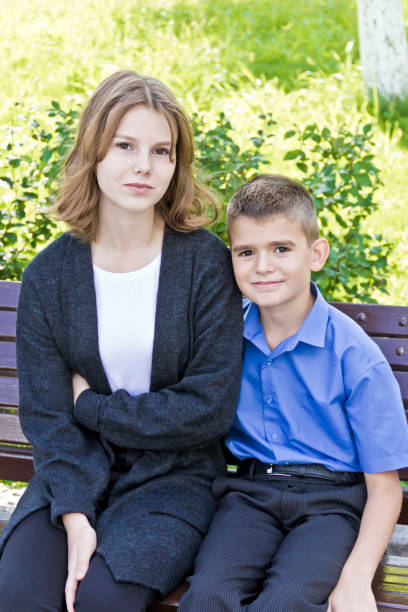 istock Brother and sister are sitting on bench 1086931368