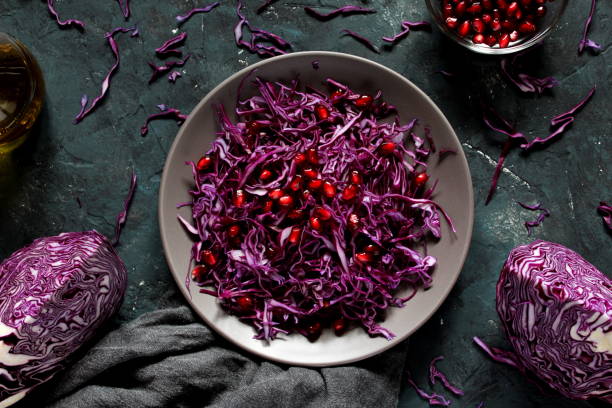 istock Red cabbage salad with pomegranate on the dark background. 1086931542