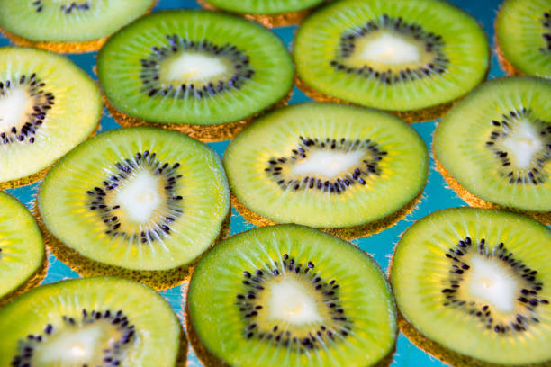 Green kiwi fruit slices on lighted glass
