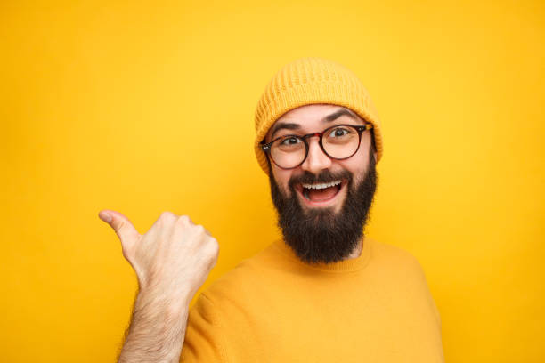 istock Colorful trendy man pointing away on yellow 1086941056