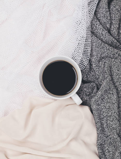 istock Cup of black coffee in white mug surrounded by different neutral toned fabrics. Flat lay. Top view. Copy space 1086943278
