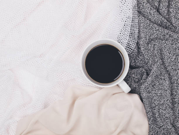 istock Cup of black coffee in white mug surrounded by different neutral toned fabrics. Flat lay. Top view. Copy space 1086943294