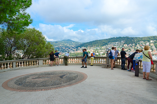 Nice, France - September 15, 2018: Unidentified tourists on observation deck in park on Roman hill (parc de la Colline du Chateau) admire beautiful view of Nice, Cote d'Azur, France